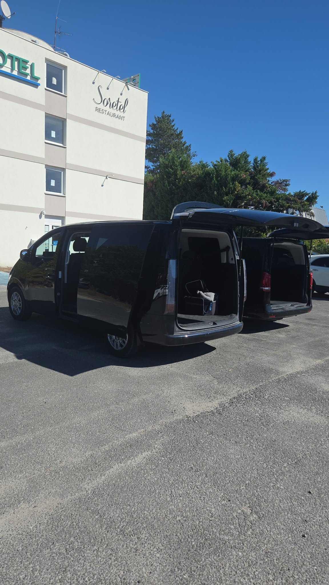 Déroulé mariage chauffeur : van VTC aux portes ouvertes devant un hôtel : déroulé horaire d'un mariage avec chauffeur